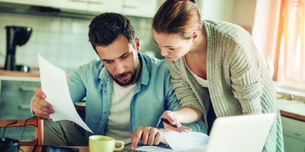 couple reviewing documents and using calculator