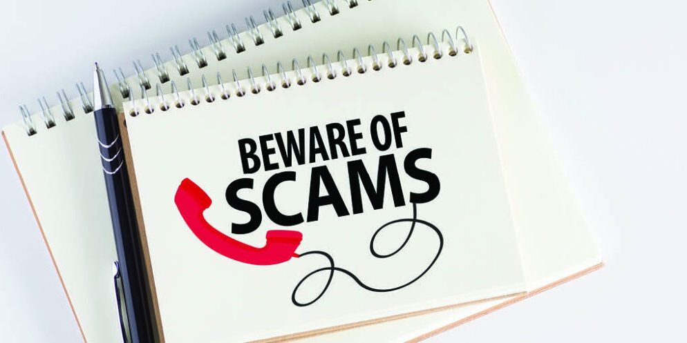 pen and notepad with beware of scams message|blood center logo and hero man